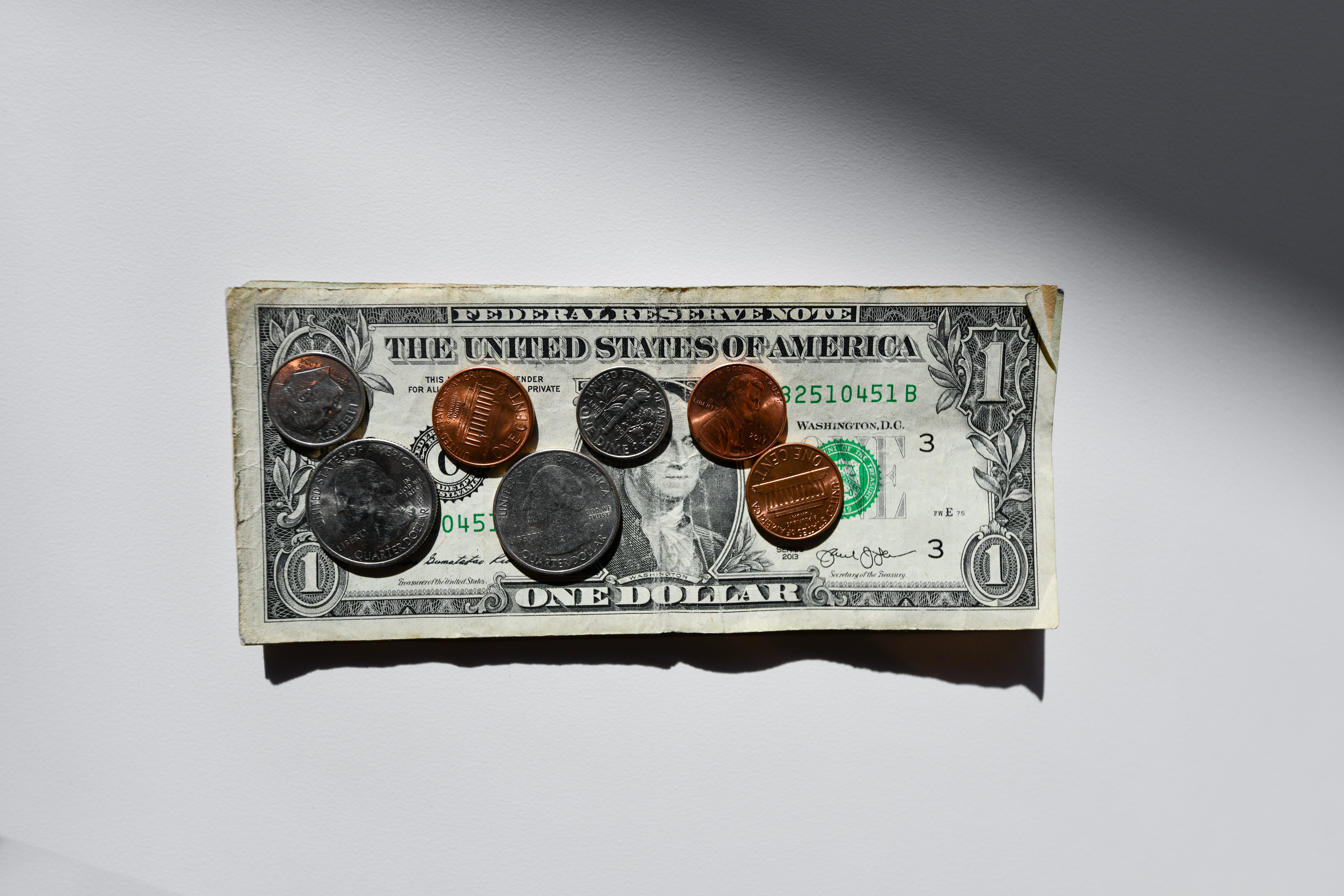 A dollar bill with cents on it.